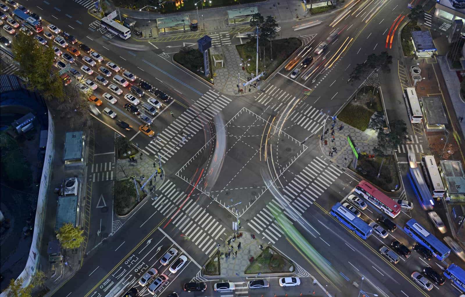 Estudo de tráfego em cruzamento urbano Cruzamento urbano movimentado à noite com ônibus e veículos