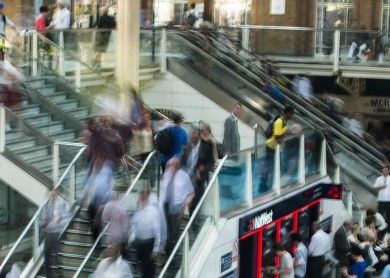 Pedestres circulando em escadas e passarelas de uma estação movimentada