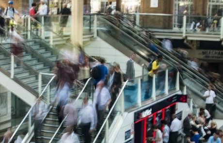 Pedestres circulando em escadas e passarelas de uma estação movimentada