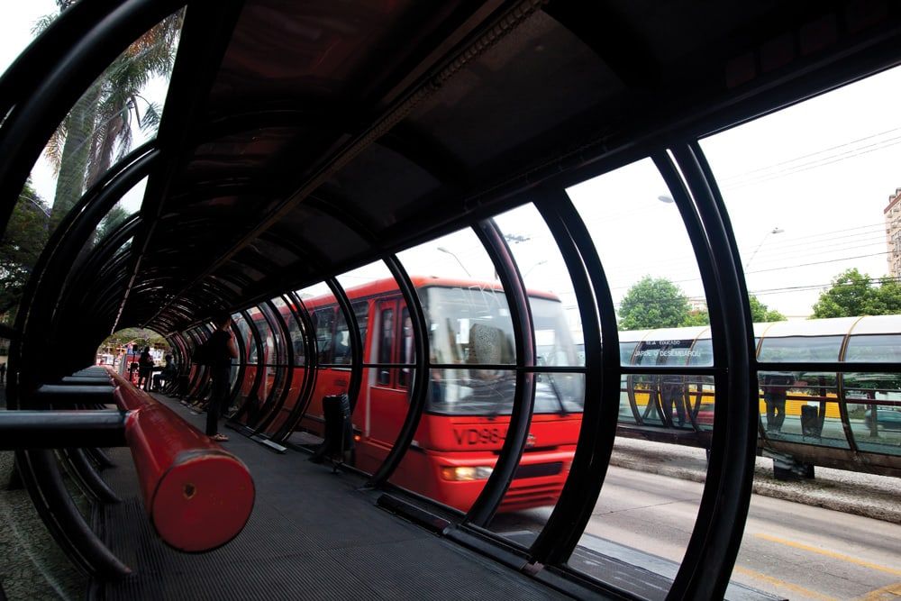 Ônibus em estação-tubo de transporte público Ônibus vermelho em estação-tubo de transporte público