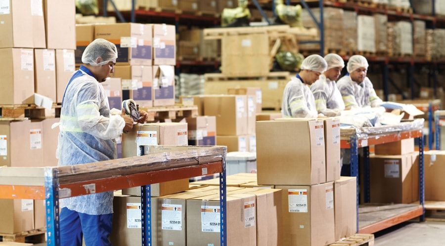 Operação em armazém industrial Funcionários organizando caixas em armazém ou área industrial