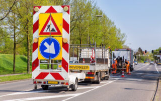 Obras viárias com caminhões e sinalização de tráfego na Holanda