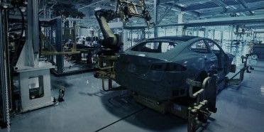 Fábrica automatizada com braço robótico na montagem de carroceria automotiva
